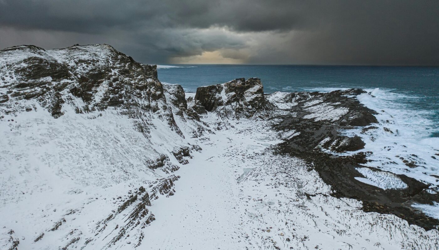 https://www.pexels.com/photo/a-snow-covered-mountain-near-the-body-of-water-6881582/