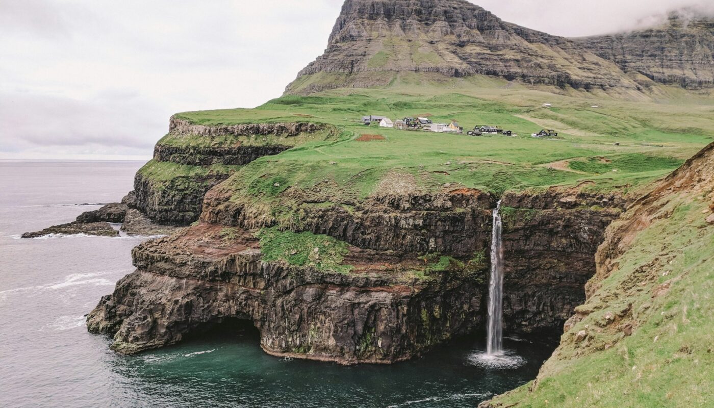 a small waterfall in the middle of a large body of water