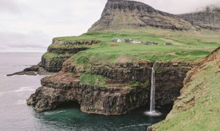 a small waterfall in the middle of a large body of water