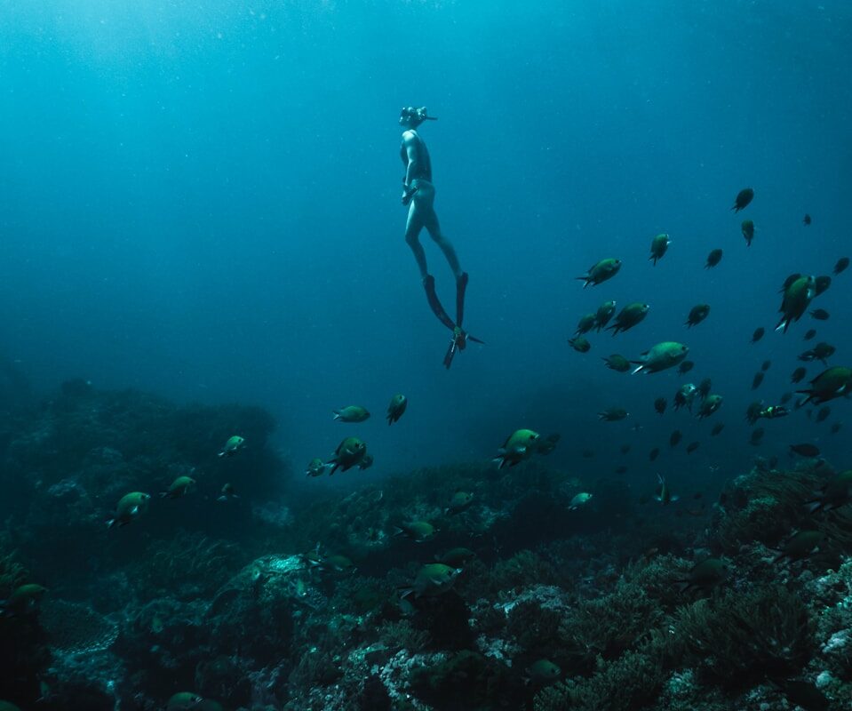 man in black shorts diving on water